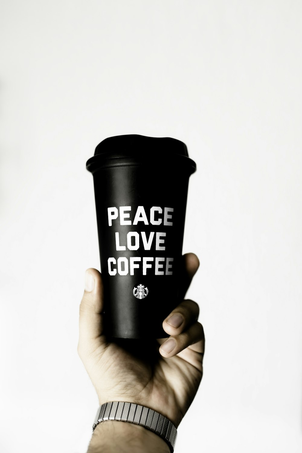 person holding peace love coffee-printed tumbler