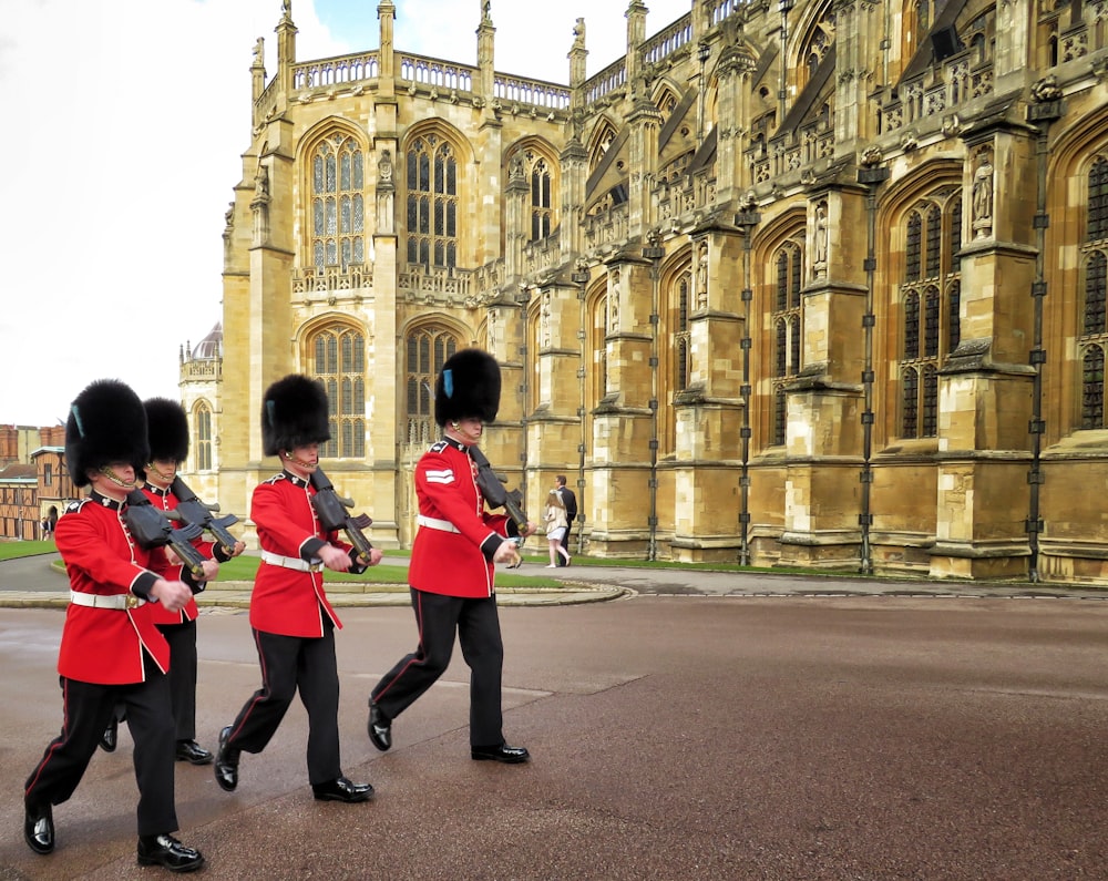 cuatro guardias reales marchando fuera del palacio