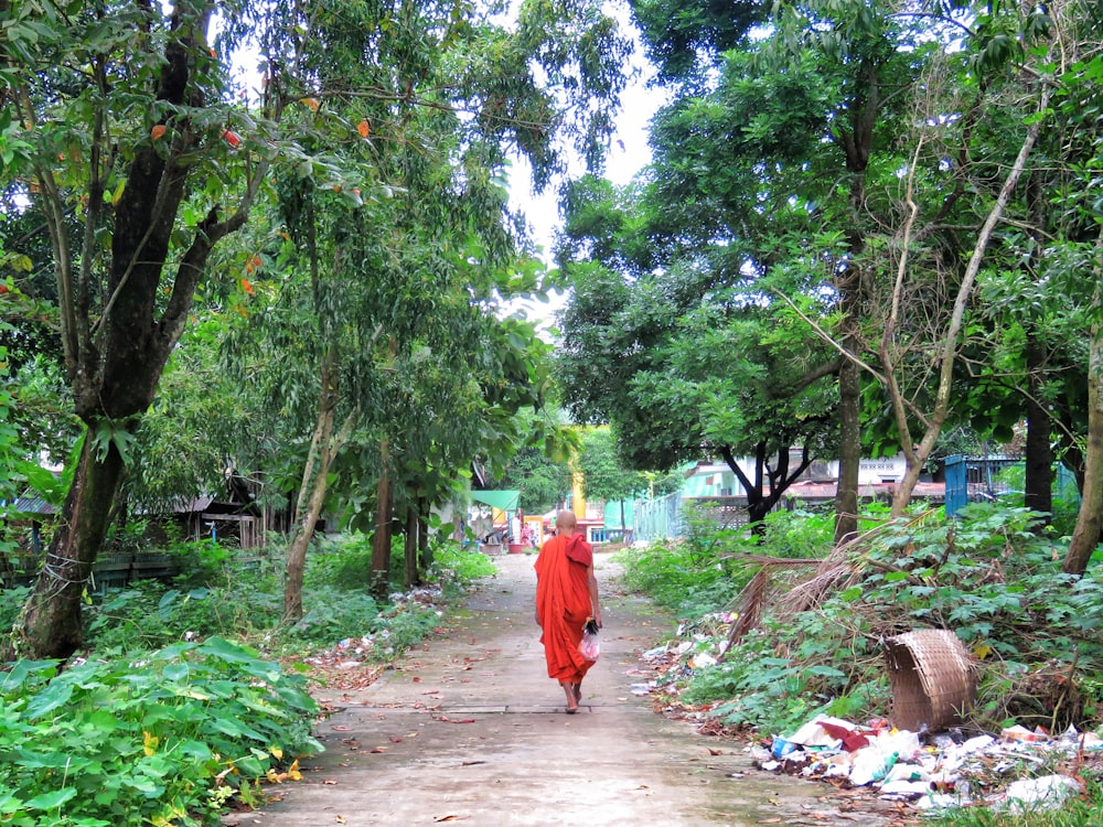 homem no terno do monge andando na estrada durante o dia
