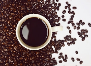 coffee cup with coffee beans close-up photography