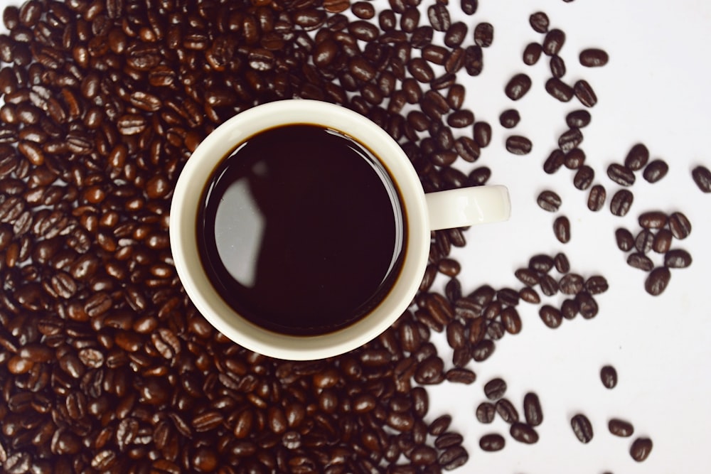 coffee cup with coffee beans close-up photography