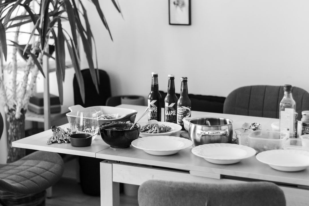  grayscale photo of dining table with plates and bowls cold tap