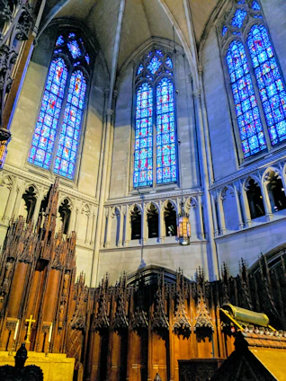 Majestic stained glass window casting colorful light inside a grand church interior.
