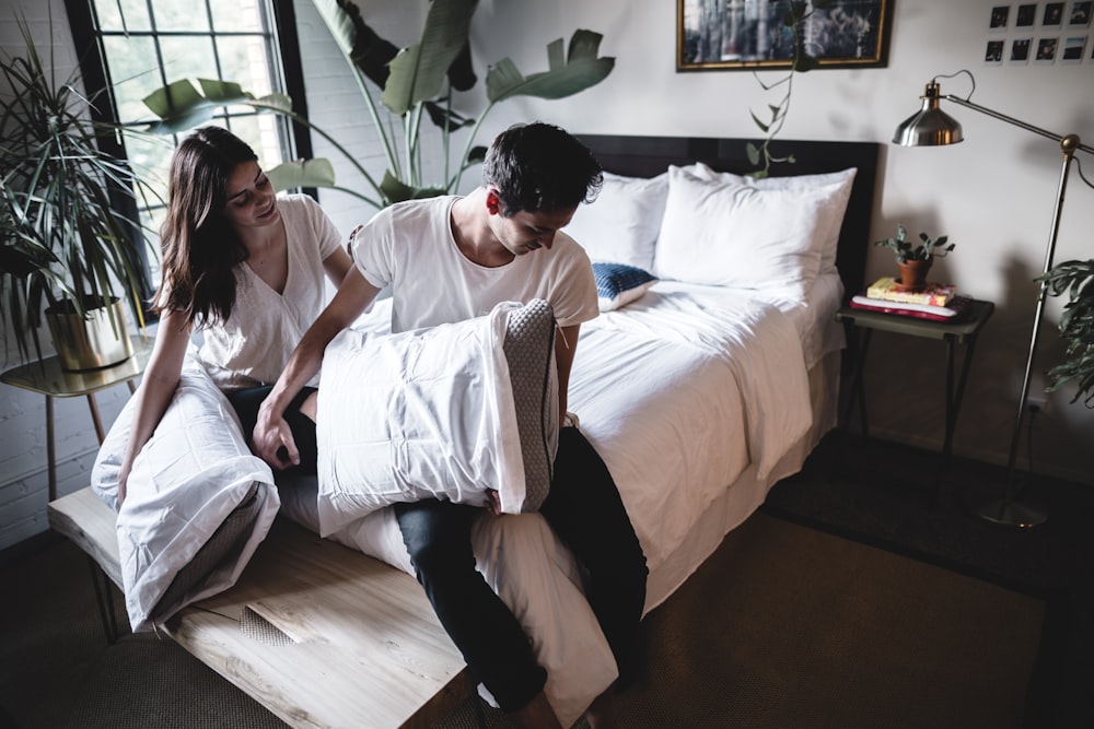 man and woman sitting on bed