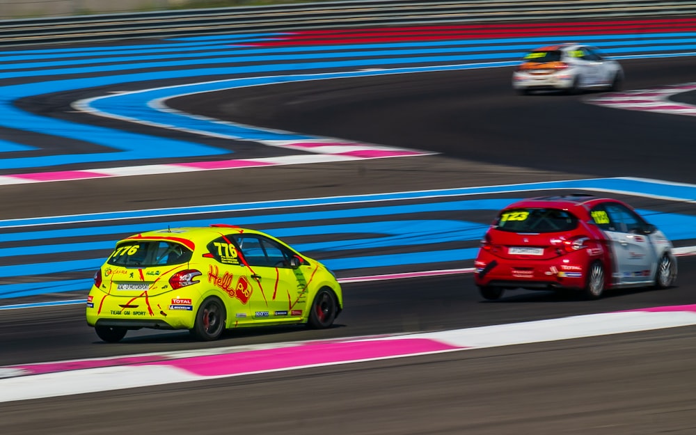 two red and yellow 2-door hatchbacks