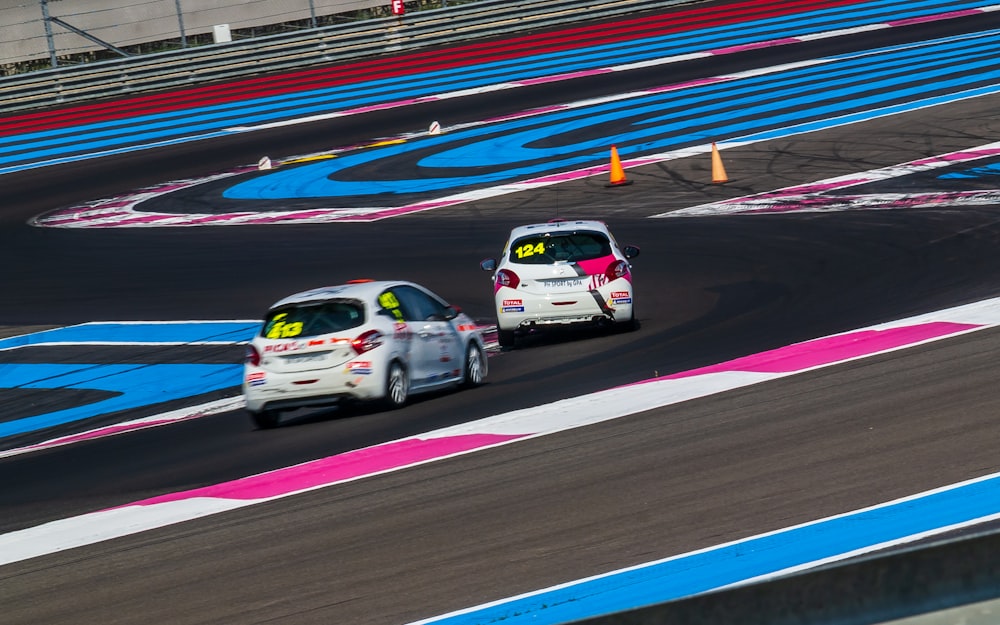 two white vehicles on race track during daytime