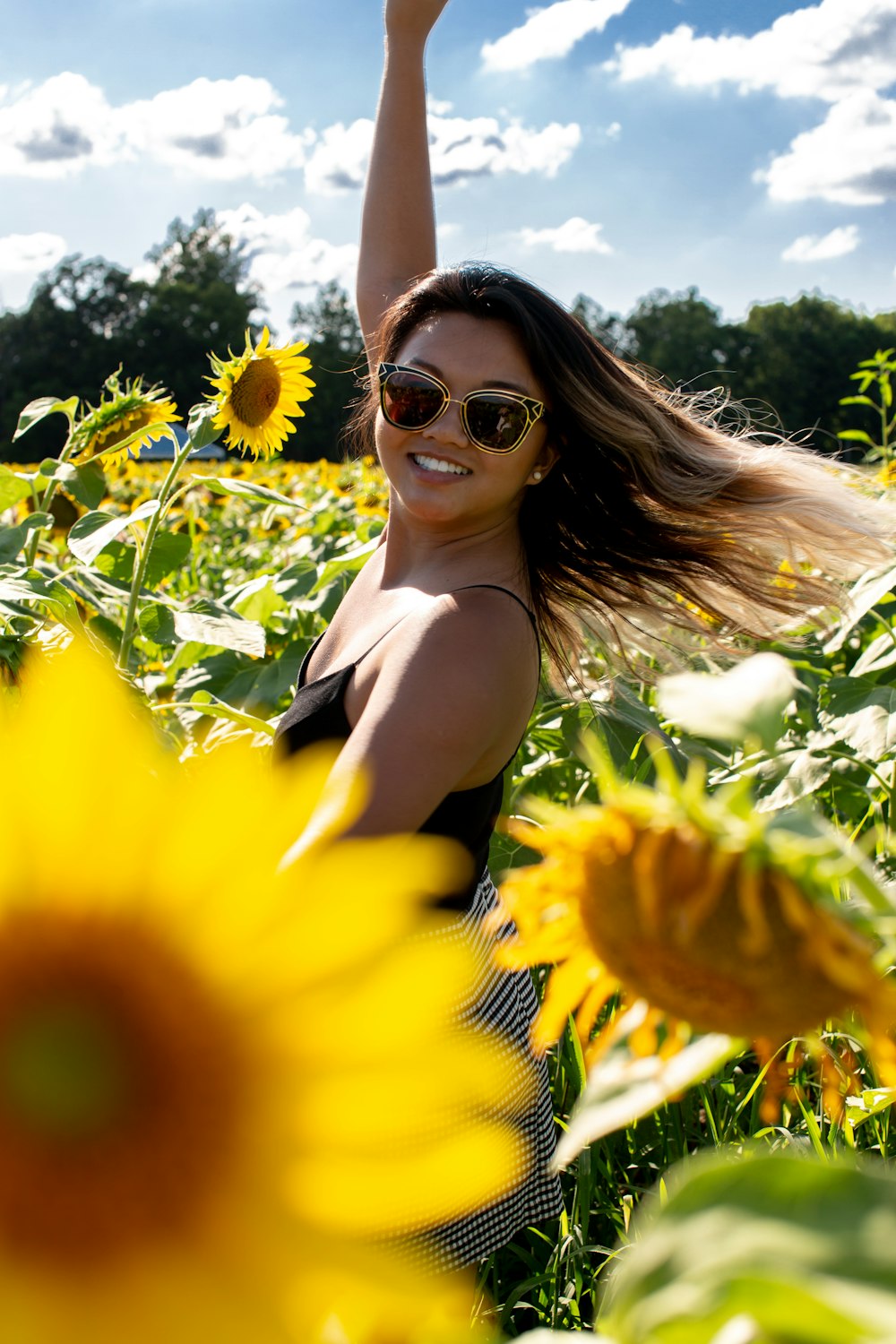 woman standing at middle of sunflower field