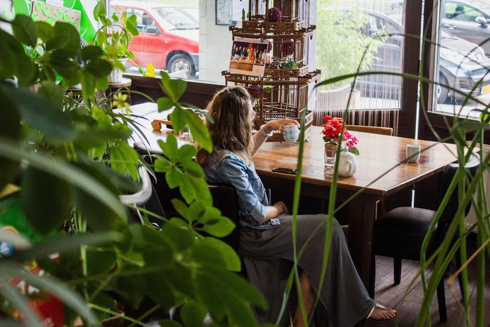 femme assise près d’une table en bois