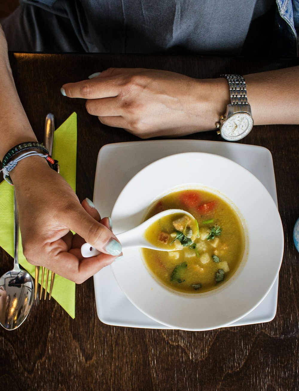 person holding spoon with soup on it