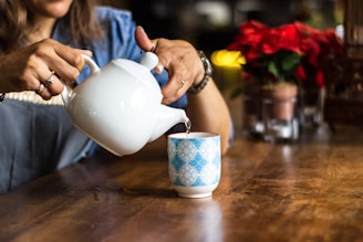 unknown person holding white ceramic kettle