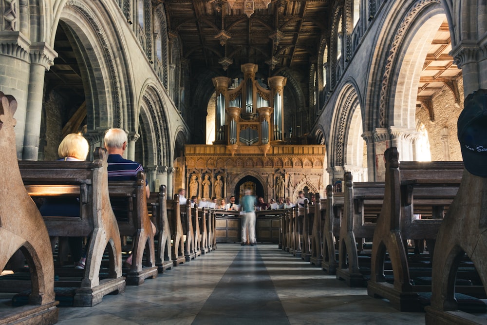 People Sitting On Pew Bench Inside Cathedral Photo Free Person