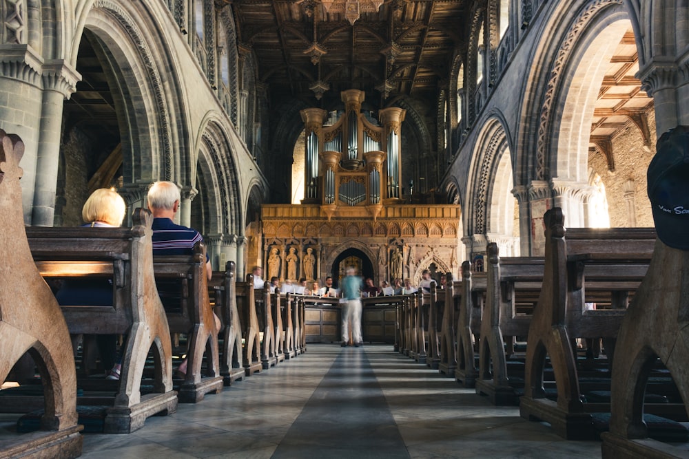 people sitting on pew bench inside cathedral