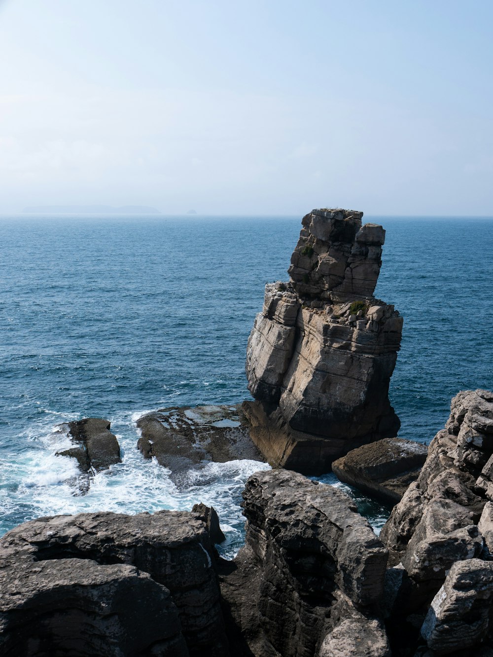 rock formation near body of water during daytime