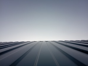 A neat, minimalist house roof with well-maintained calhas and a clear sky background