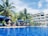A vibrant pool area surrounded by palm trees and guests enjoying drinks.
