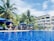 A vibrant pool area surrounded by palm trees and guests enjoying drinks.