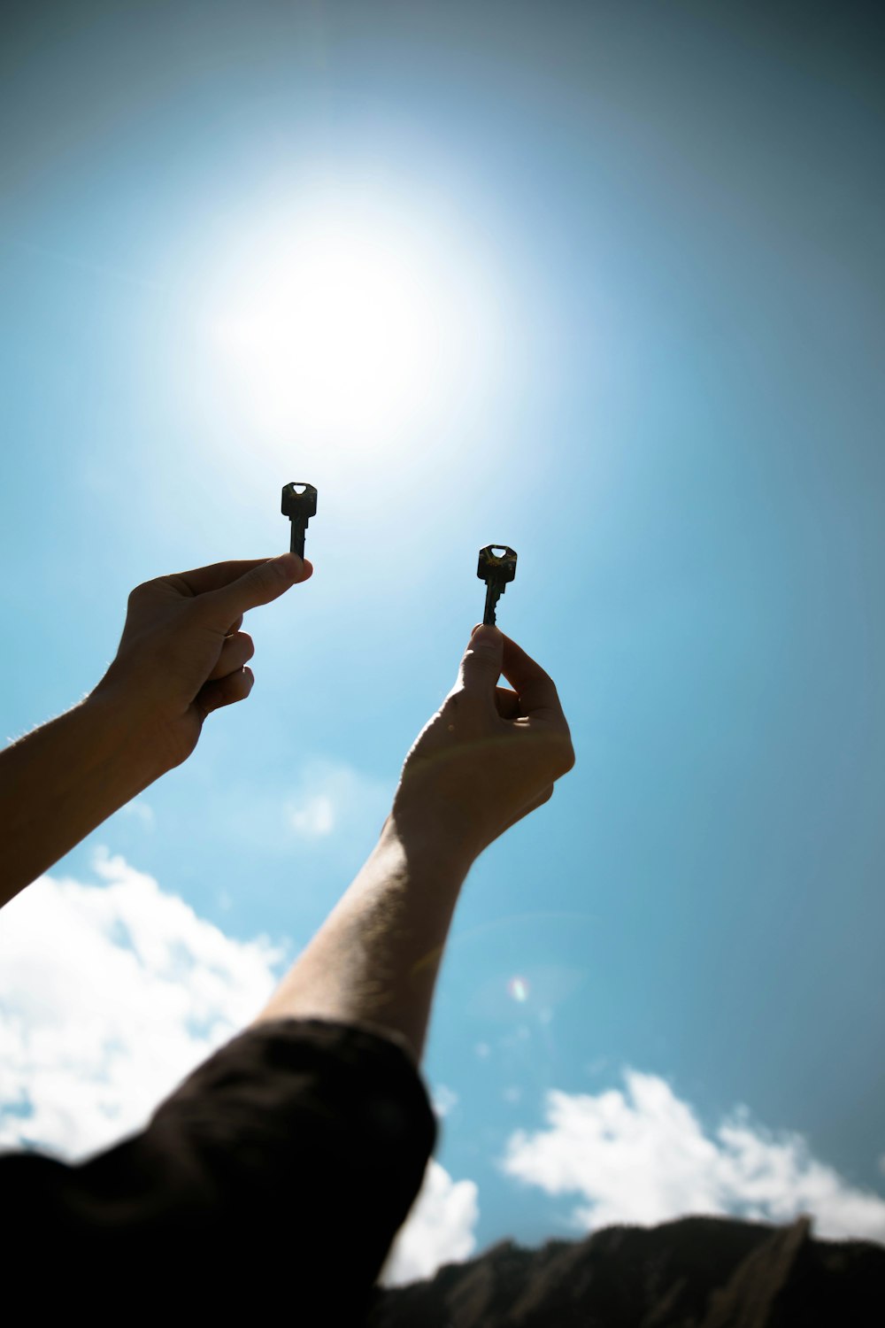 person holding two keys during daytime