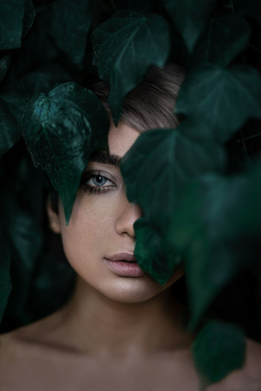woman standing behind plants