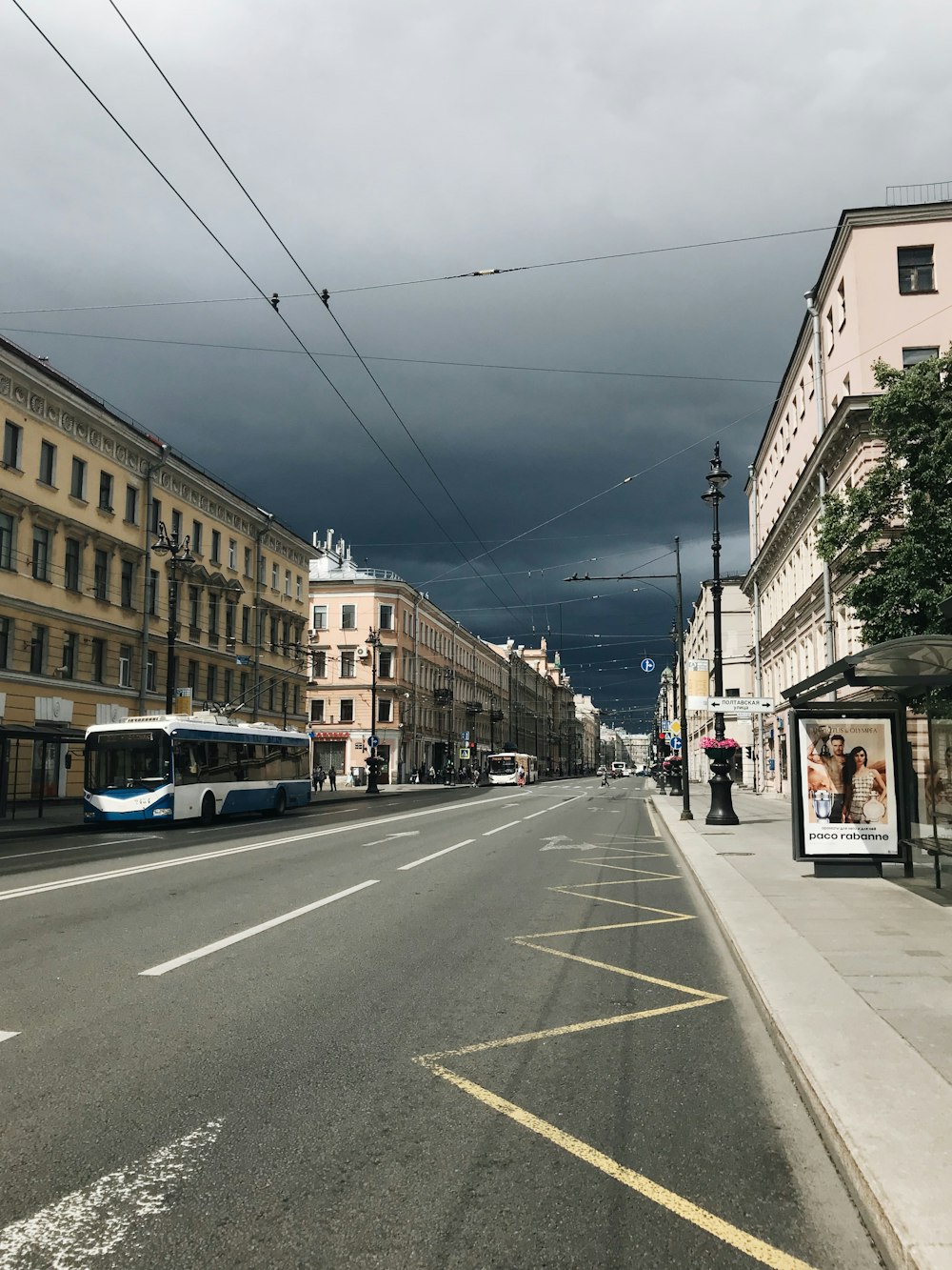 bus parked along side road near buildings under clouded sky