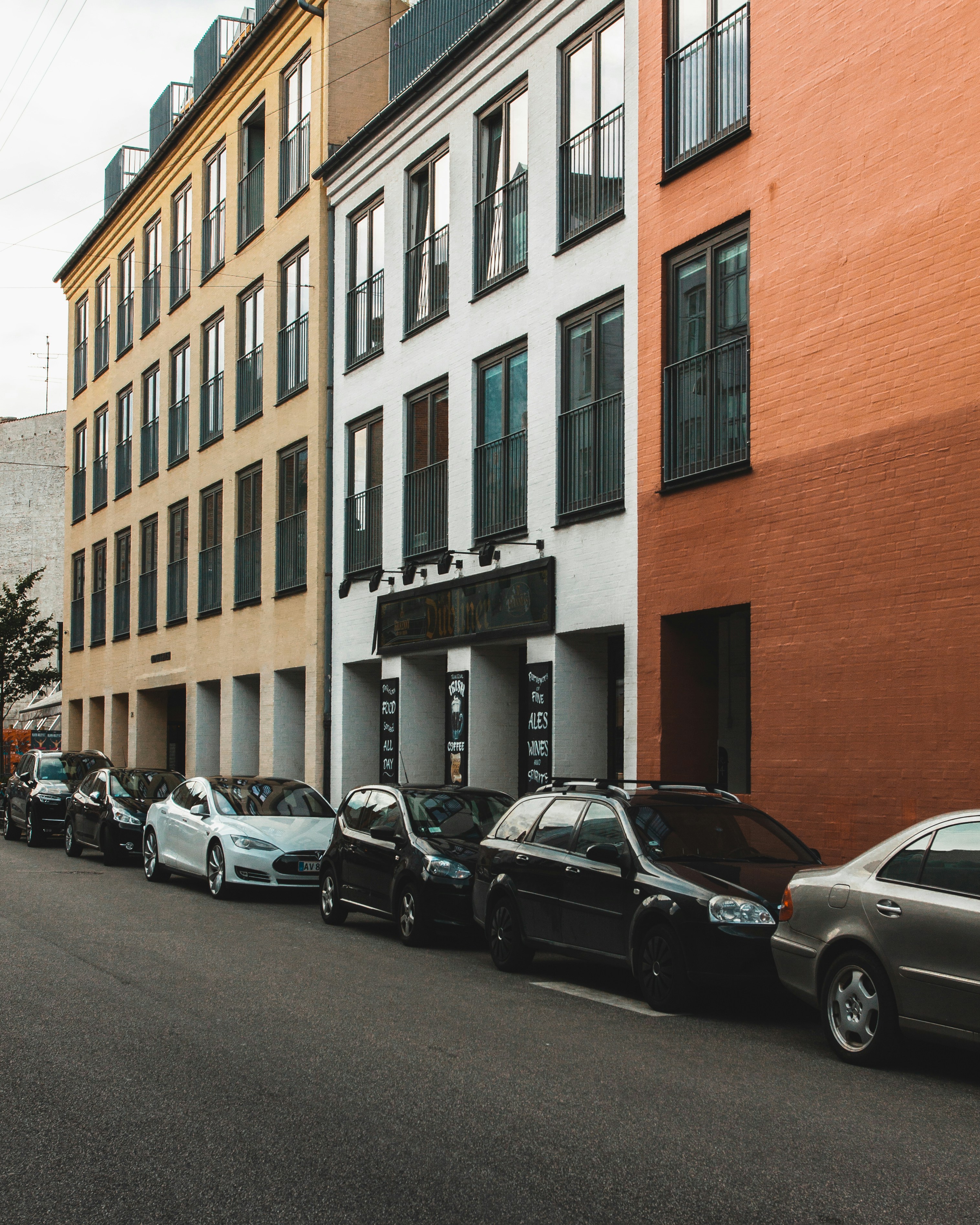 car lot parked beside buildings during daytime