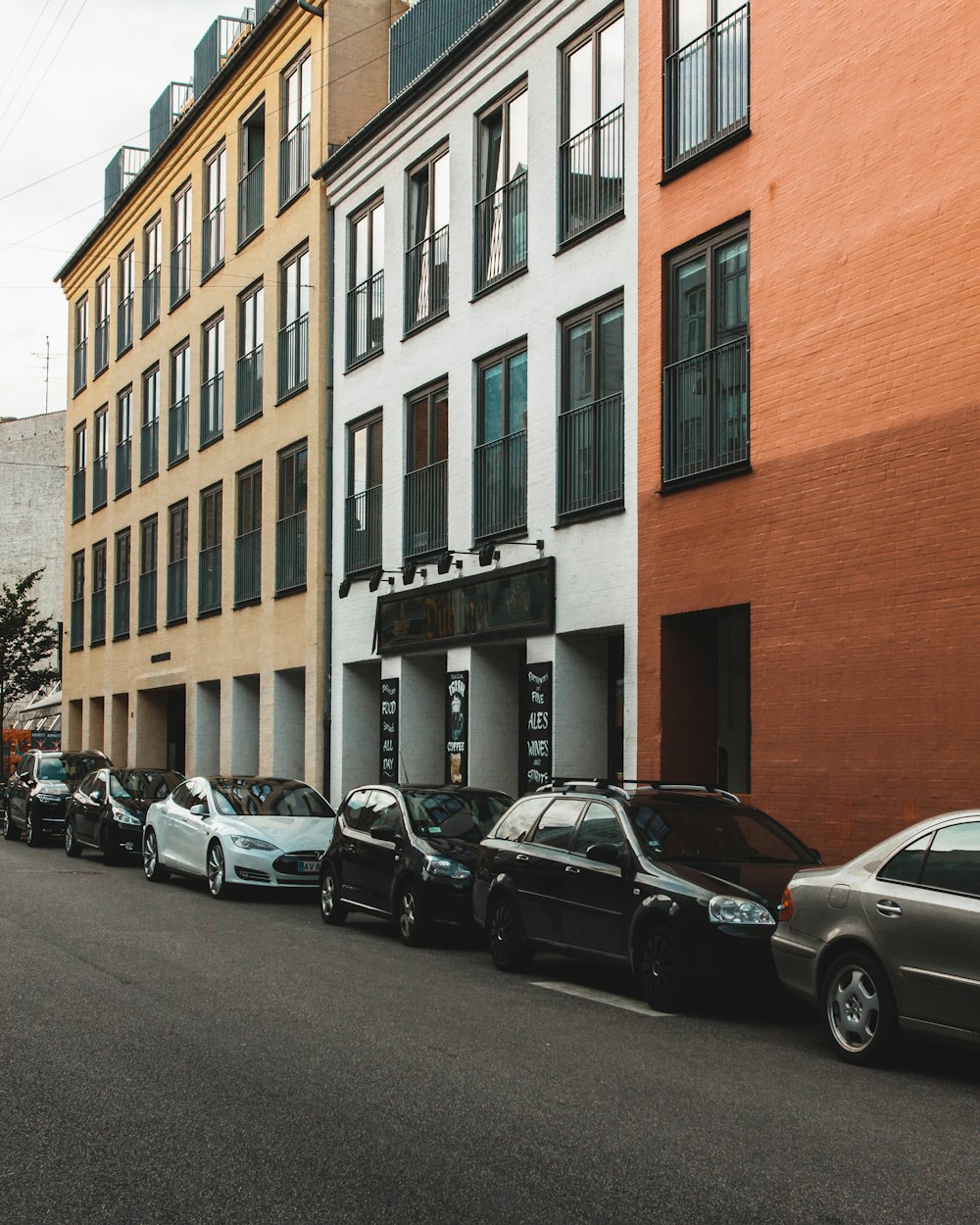 car lot parked beside buildings during daytime