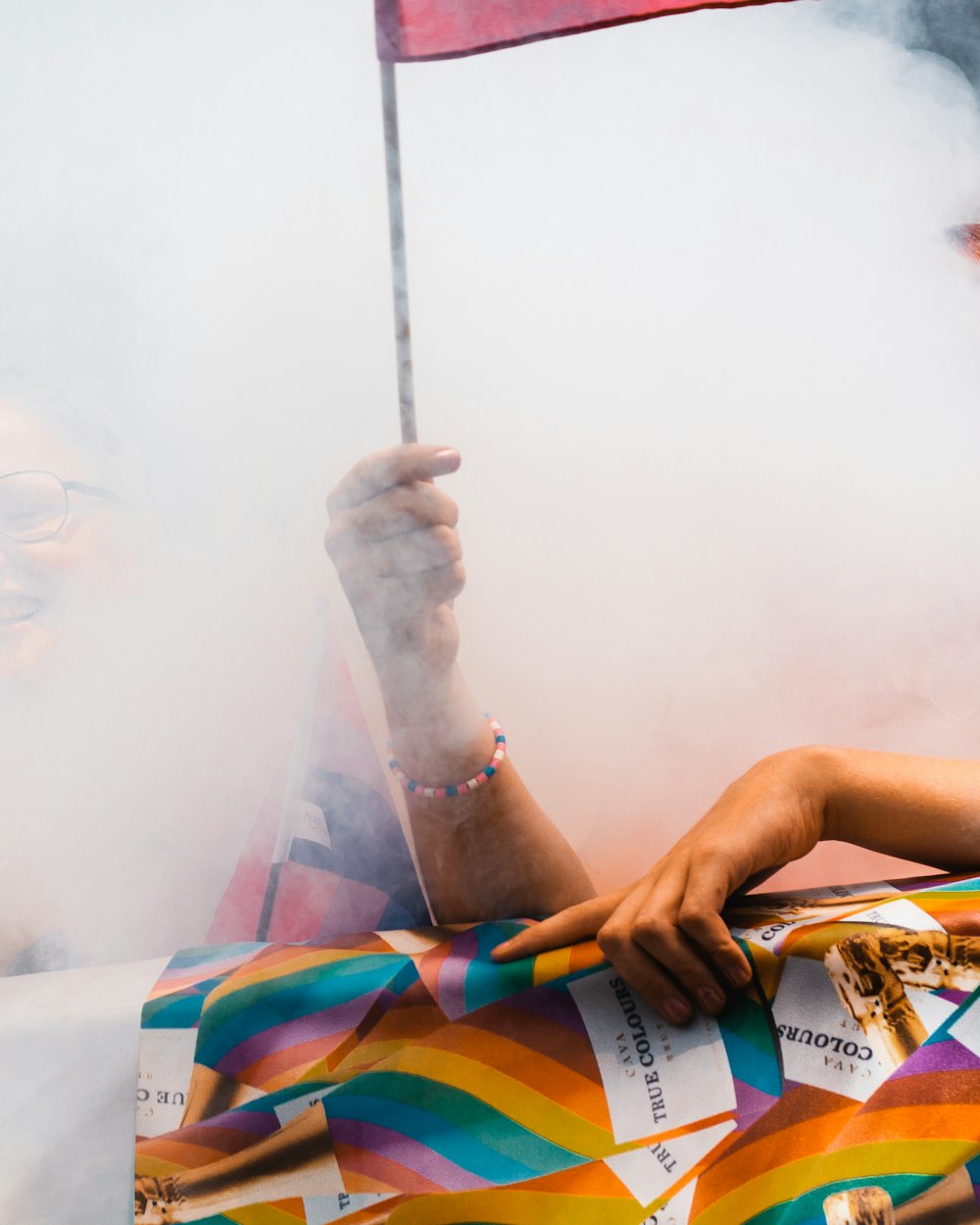 a person holding a flag and smoking a cigarette