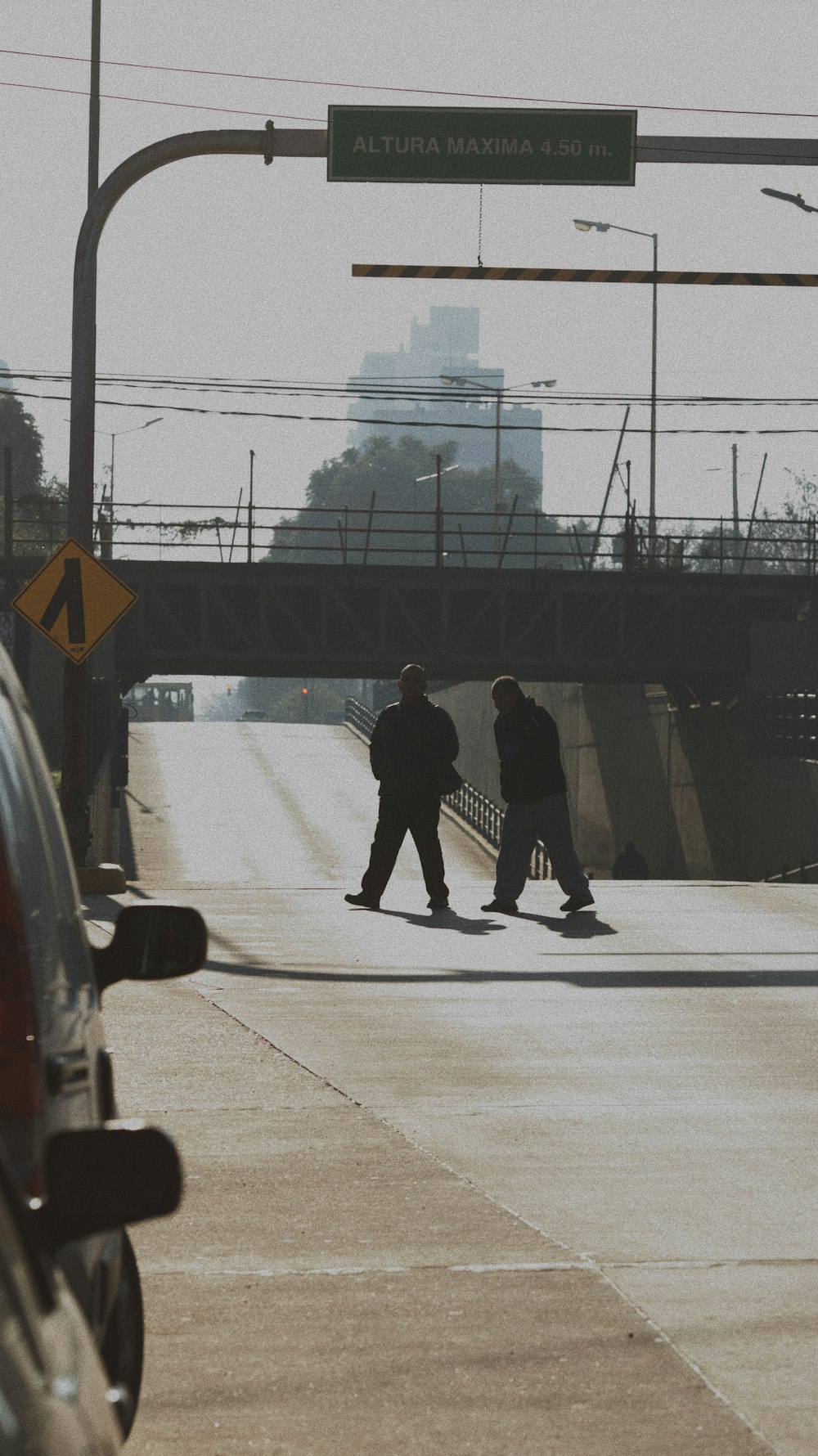 two men walk across the street