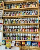 Colorful assortment of bottled soft drinks lined up on a wooden counter.