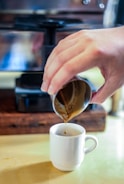 A scientist in a lab coat measuring coffee extraction with precision tools.