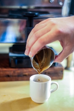 A scientist in a lab coat measuring coffee extraction with precision tools.