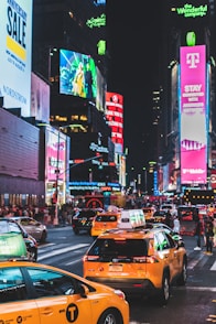 vehicles on road beside high buildings at nighttime