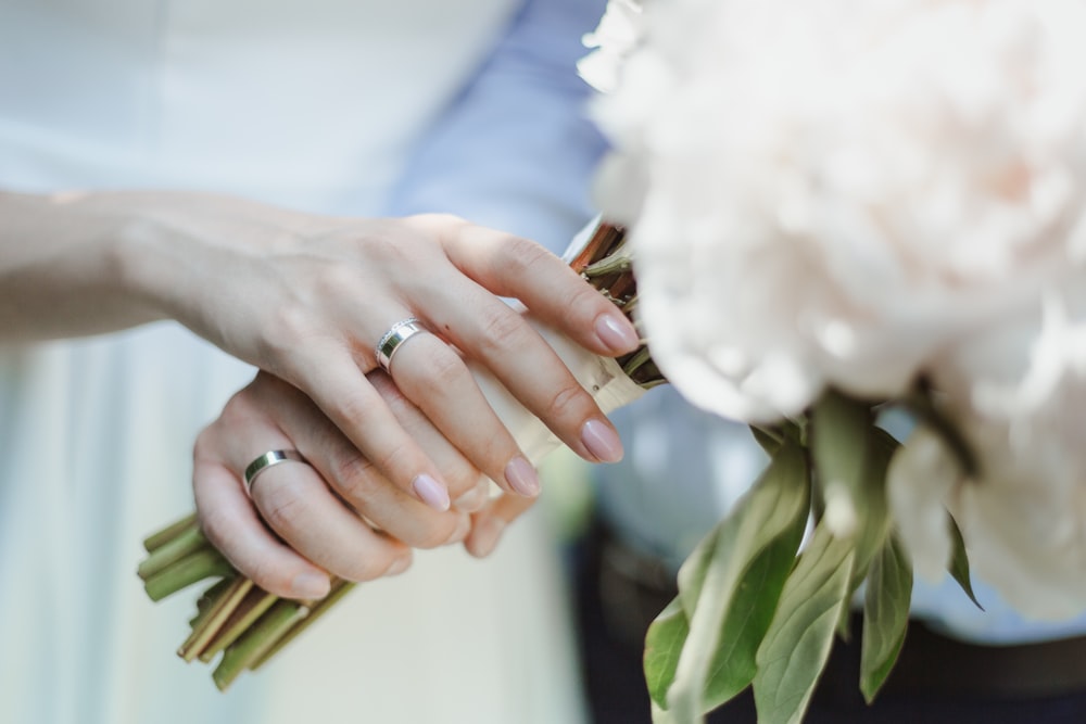 shallow focus photography unknown person holding white flower bouquet