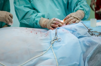 person in operation gown holding scissors