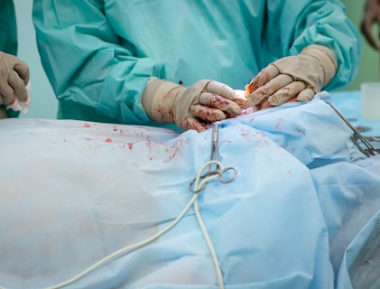 person in operation gown holding scissors