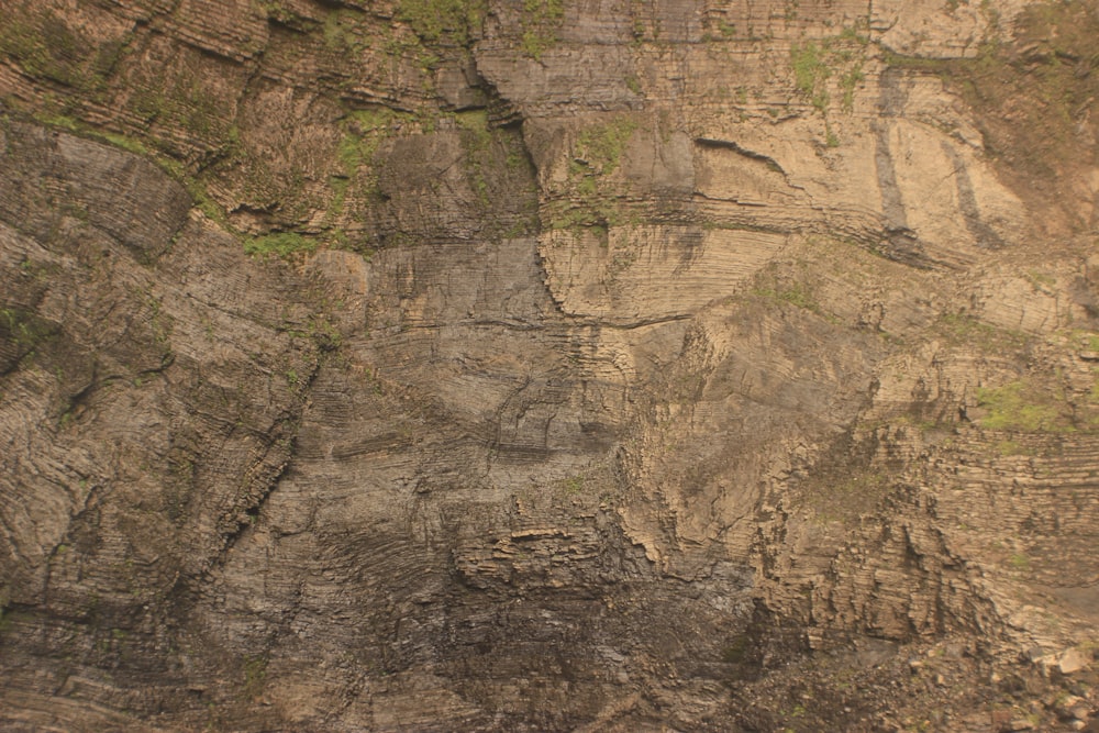 a man riding a surfboard on the side of a cliff