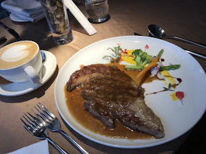 Fresh vegan dishes beautifully plated next to a steaming cup of coffee.