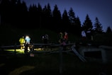 Evening search operation with volunteers using flashlights in a wooded area.
