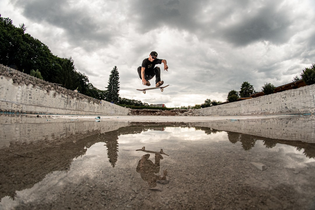 man doing skateboard stunt above water