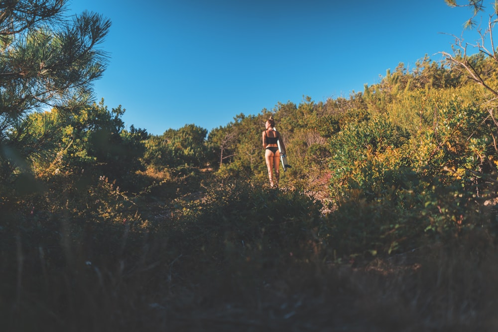 woman in black bikini standing on top of the hill