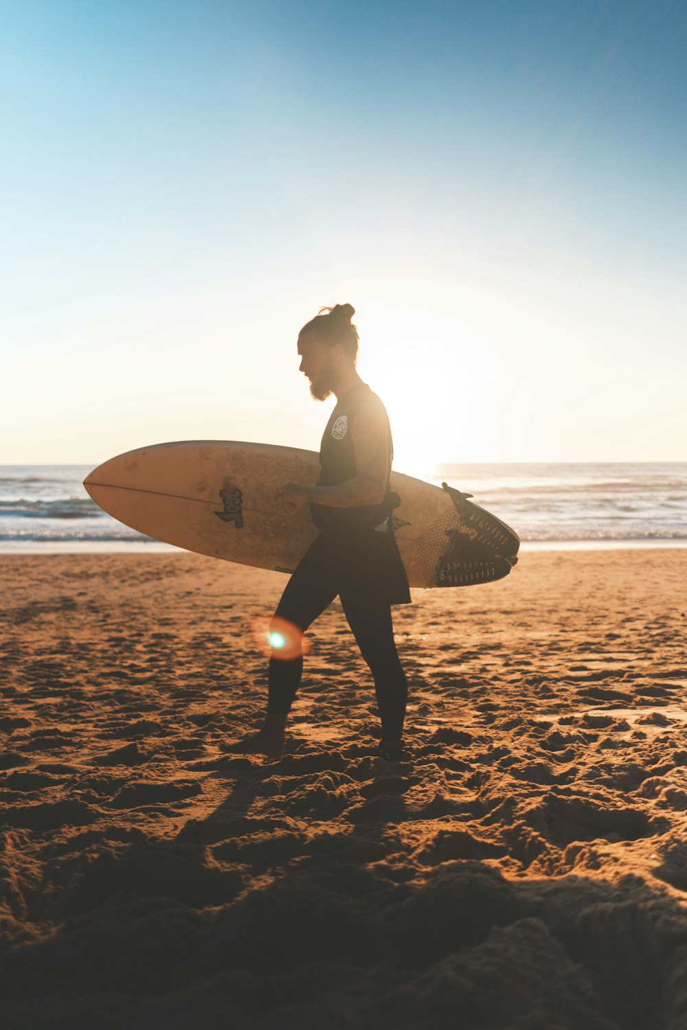 man walking on seashore with surfboard