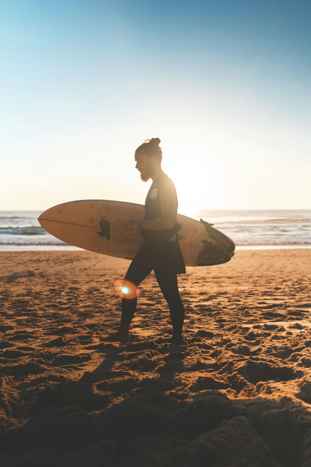 man walking on seashore with surfboard