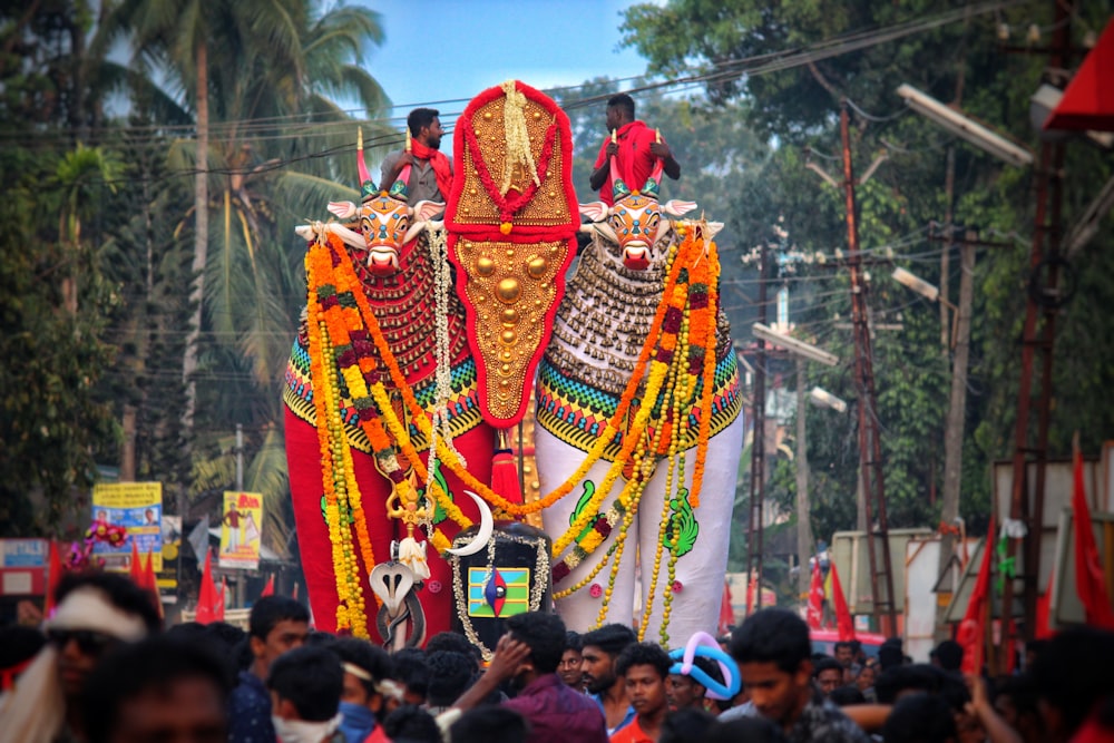 a large colorfully decorated elephant in the middle of a crowd