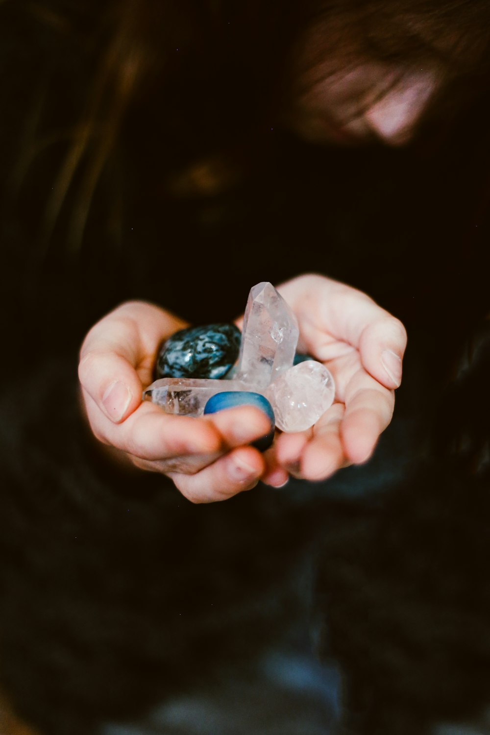 white and green gemstones on person palm