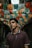 man in brown polo shirt standing in between houses
