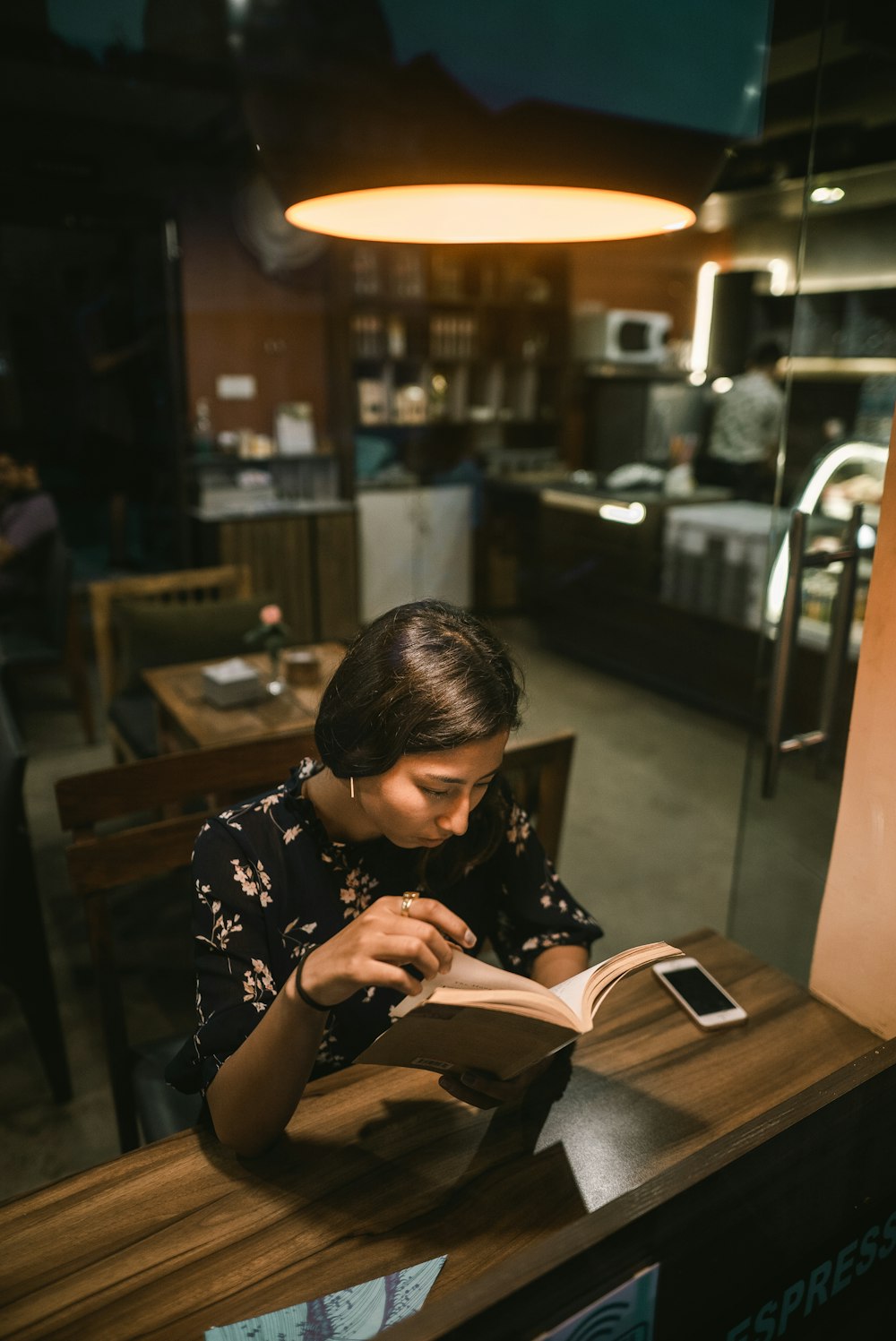 woman reading book beside table