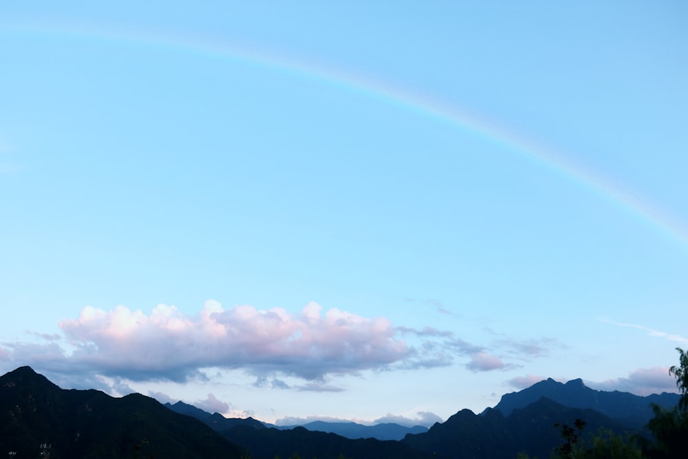 rainbow over the white clouds and mountains