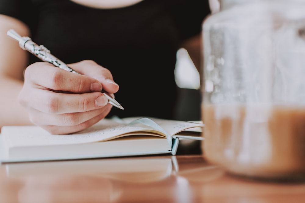 person writing on book