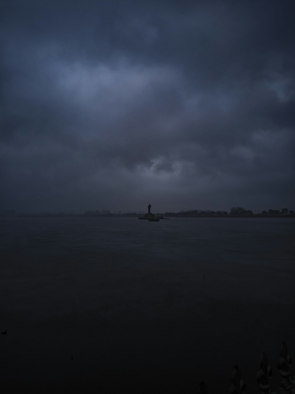 港の灯台に迫る灰色の雨雲
