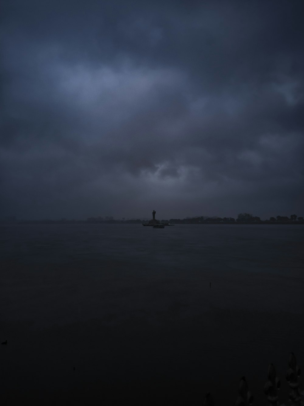 grey rain clouds looming over the lighthouse at the harbor