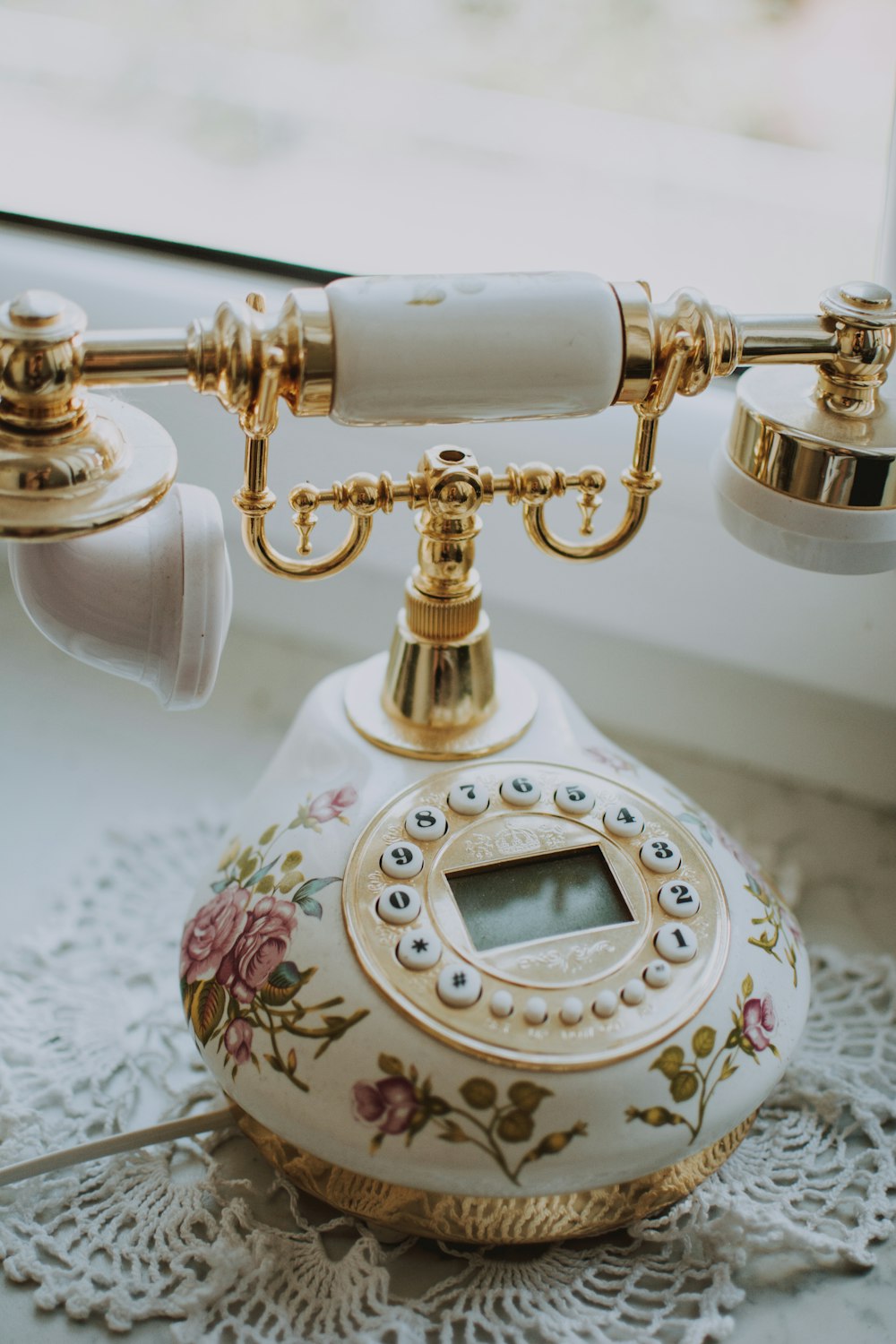 white and gold floral telephone on mat